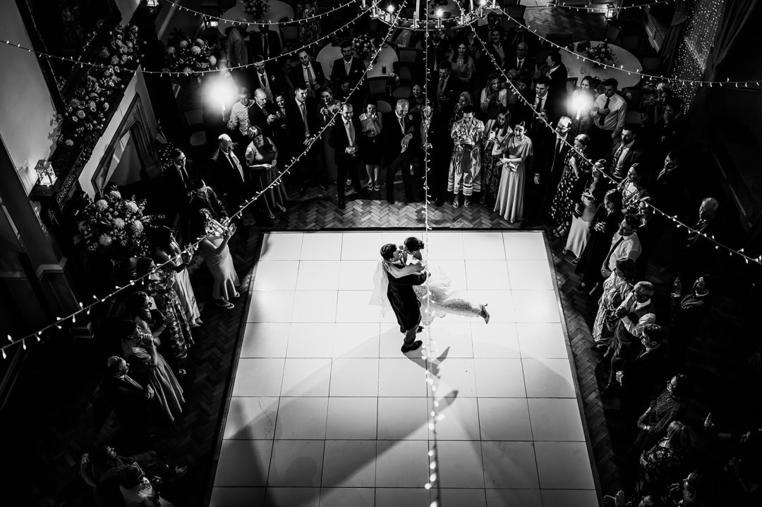 Groom swinging his bride around the dance floor for their first dance at Farnham Castle