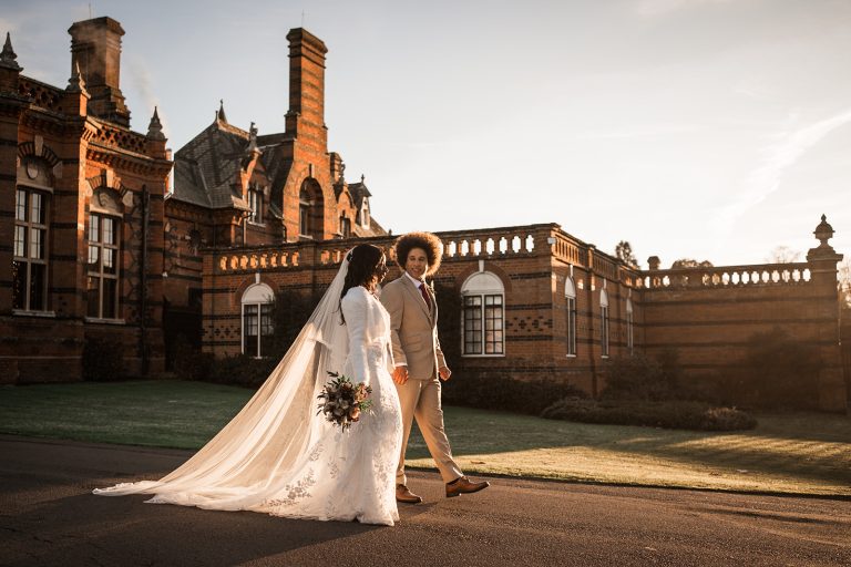Wedding couple strolling outdoors at sunset at The Elvetham Wedding Venue
